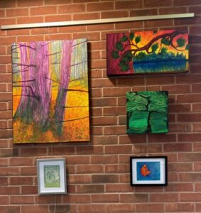5 paintings mounted on a brick wall